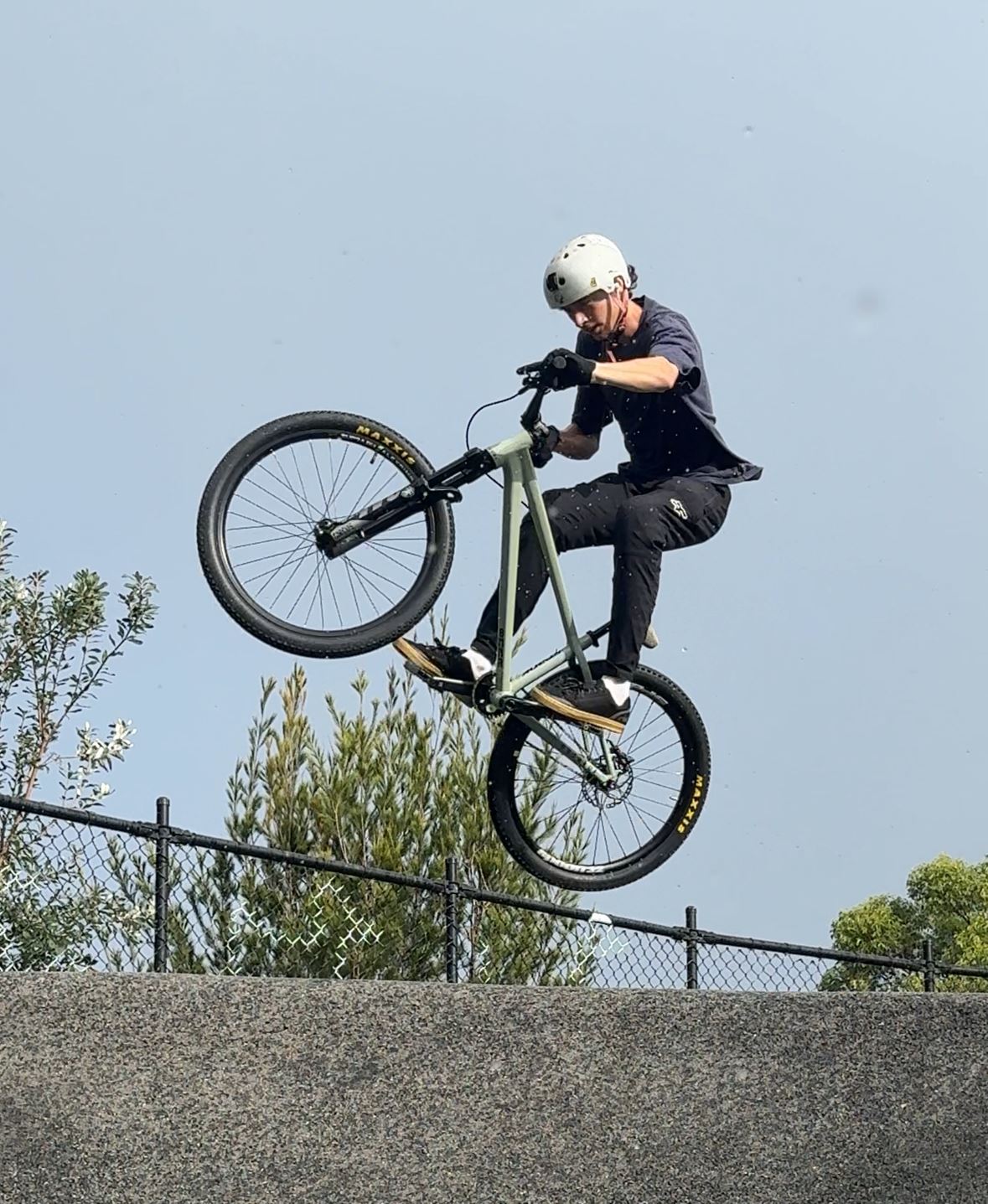 Rider clearing a dirt jump on a hardtail mountain bike